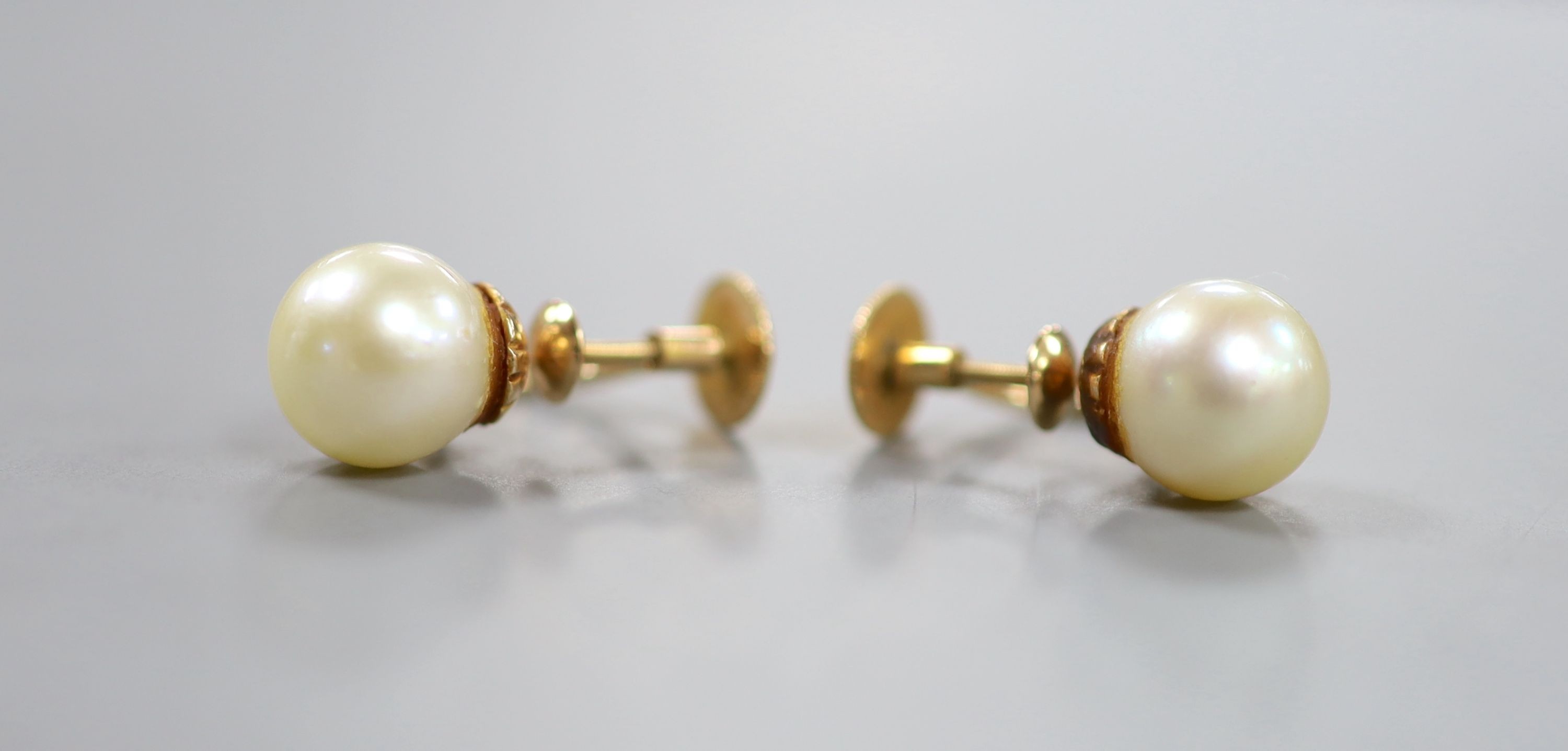 A pair of yellow metal and cultured pearl ear clips, pearl diameter 9mm, gross weight 4.1 grams.